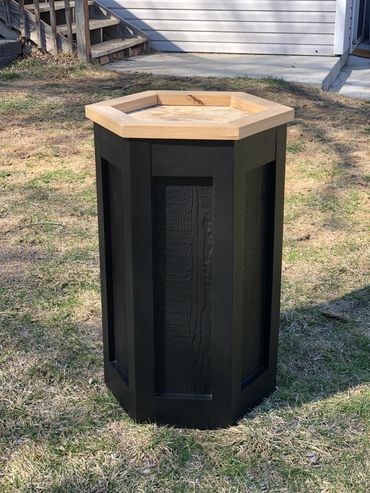 Black hexagon pedestal for deer mount with natural oak top.