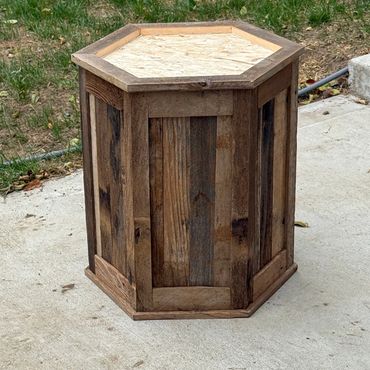 A custom barnwood taxidermy base built half the size of a normal pedestal in the shape of a hexagon.