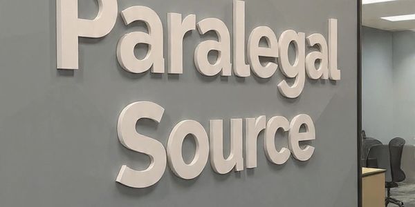 Sign reading 'Paralegal Source' on an office wall.