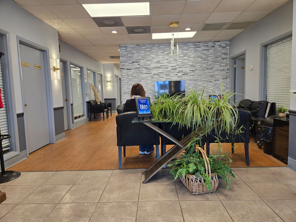 Modern waiting area with plants and a person seated.