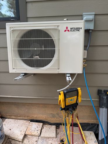 Mitsubishi Electric air conditioning unit with diagnostic equipment attached.