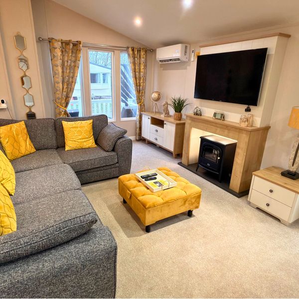 Modern living room with gray couch and yellow accents.
