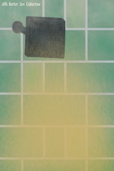 Black square shower head misting yellow water with a teal green subway tile background
