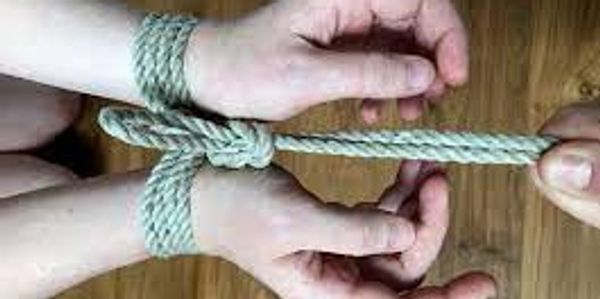 white person's wrists bound in cotton rope