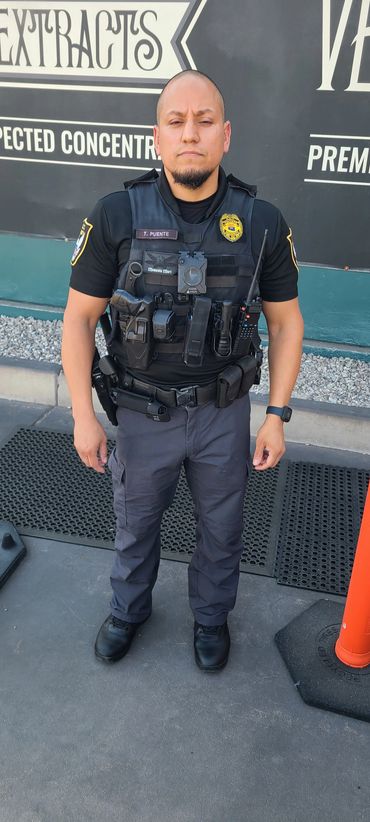 Uniformed officer standing outdoors near a building.