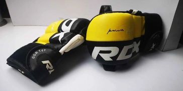 Pair of yellow and black RDX boxing gloves on a white surface.