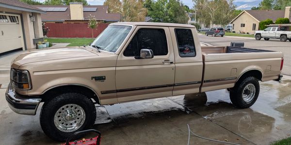 A beige pickup truck parked in a driveway.