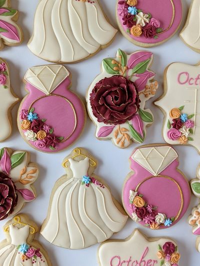 Wedding or bridal shower sugar cookies, including a gown, floral cluster, ring, and calendar