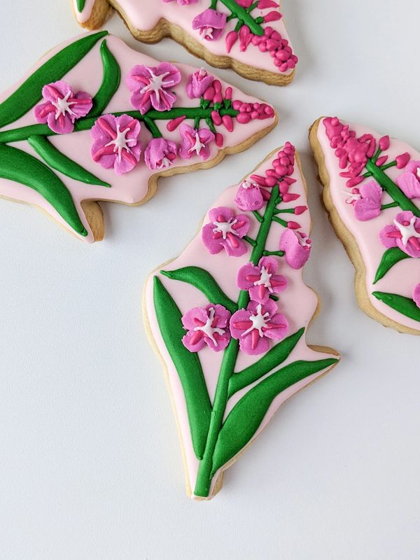 Sugar cookies decorated to look like fireweed on a white background