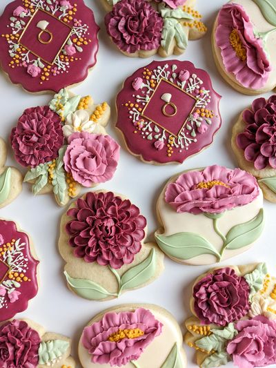 Floral sugar cookies with burgundy, pink roses, carnations, dahlias, and wedding rings