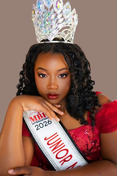 Young beauty queen wearing a crown and sash.
