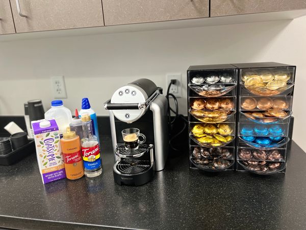 Coffee machine, espresso bar with 8 kinds of coffee, syrups atop a black granite countertop
