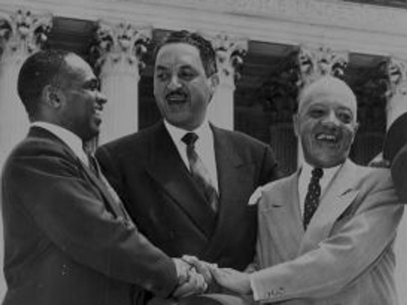 three men shaking hands and smiling