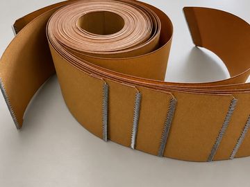 A coiled strip of brown cardboard with metal staples along one edge.