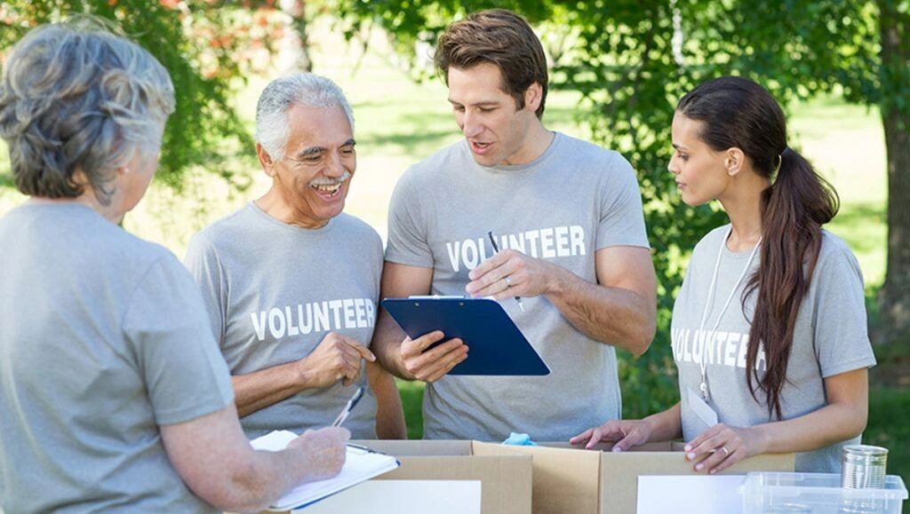 Group of volunteers organizing donations outdoors with clipboards.