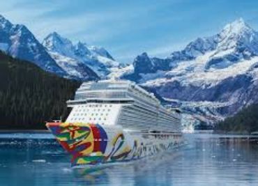 A colorful cruise ship sailing in icy mountain waters.
