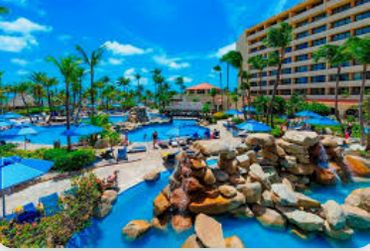 Resort pool area with palm trees and blue skies.