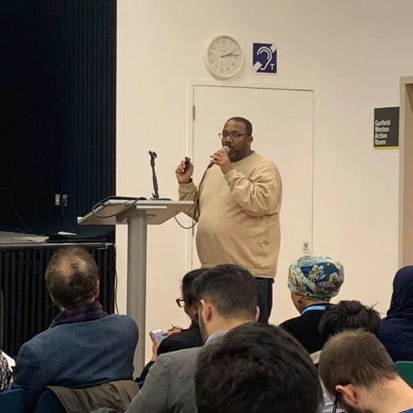 A man speaking in front of a group of people