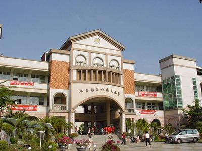 校园建筑主入口,学生在广场上活动。