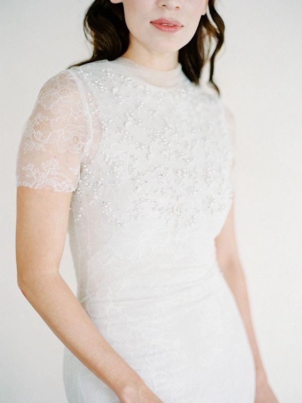 Bride in a beaded, embellished sleeved wedding dress