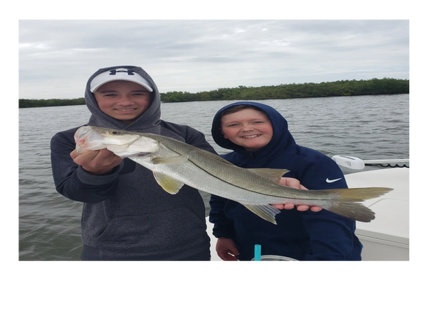 clients with a snook they caught during inshore fishing trip