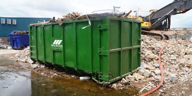 Rollonoff bin on construction site with builders rubbish in it.  green wilrose rolonoff.