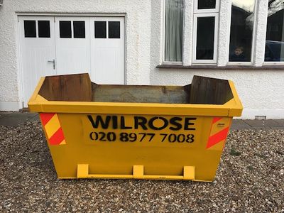 Yellow 6yard skip on driveway.  looking at the end of the skip.