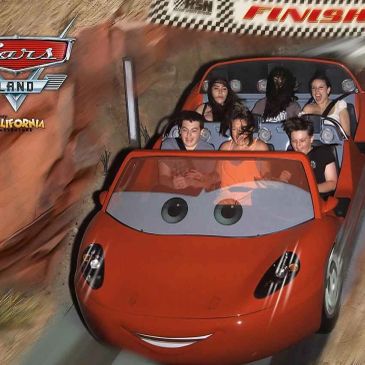 People enjoying a ride in a Cars Land themed car at Disneyland California.