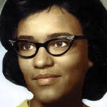 Portrait of a woman wearing vintage black cat-eye glasses.