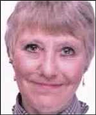 Portrait of an elderly woman smiling gently.