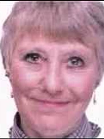 Portrait of an elderly woman smiling gently.