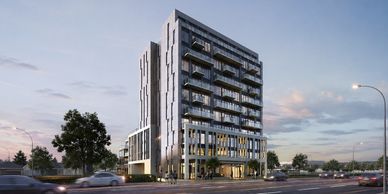 Modern multi-story building with glass balconies and illuminated lower floors at dusk.