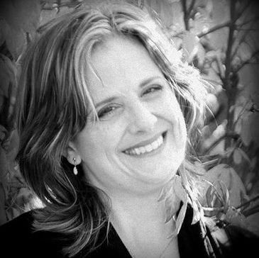 Black and white photo of a smiling woman with shoulder-length hair.