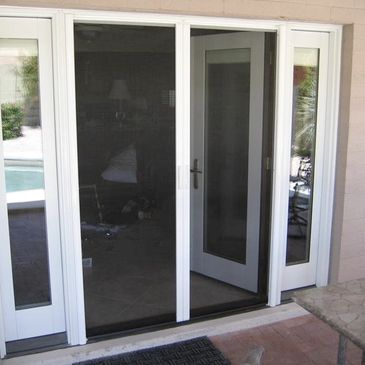 White-framed sliding glass door with a screen door leading to a patio area.
