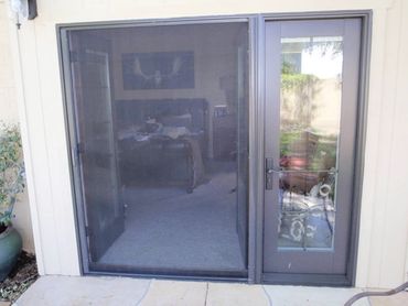 Sliding glass door with screen leading to a cozy living room.