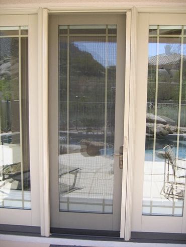 A glass sliding door with a reflection of outdoor patio and pool.