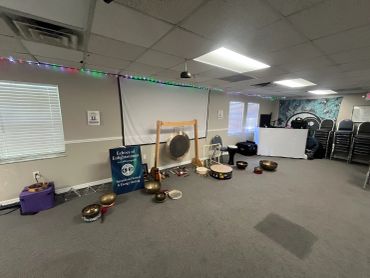 A collection of sound bowls and gongs in a spacious room.