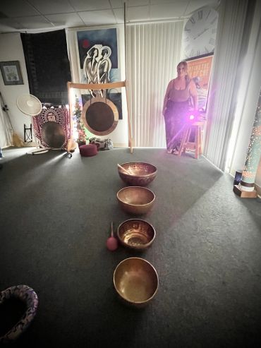 Room with singing bowls and a person taking a photo in the mirror.