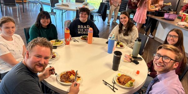 Group of people enjoying a meal together at a round table.