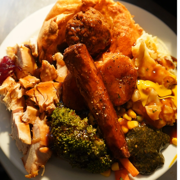 Hearty plate of roast dinner with vegetables and sides.