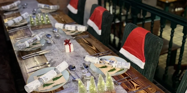 Festive holiday dining table setup with Christmas decorations.