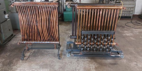 Two copper radiator units on wheels in a workshop.