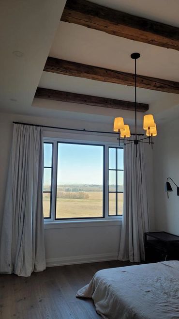 Hand Hewn pine timbers from 1870's attached to the ceiling to create an inviting bedroom space.