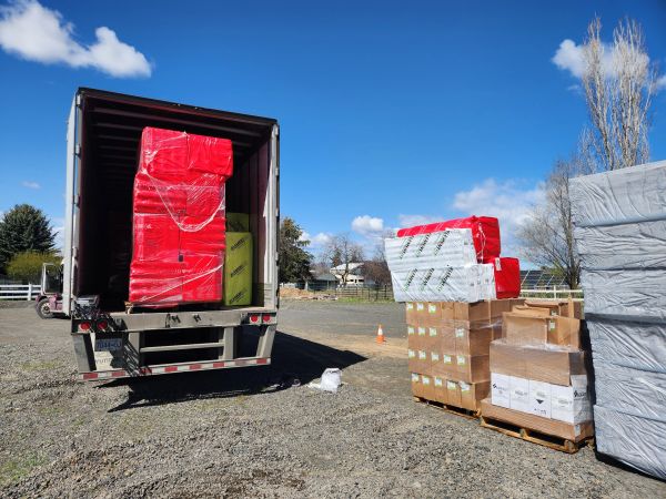 Open truck loaded with wrapped packages at a sunny outdoor location.