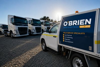 O'Brien Auto Electrics service vehicle parked near trucks under a clear sky.