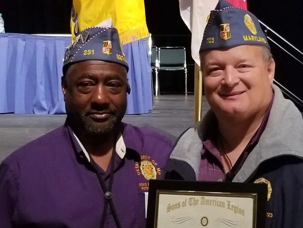 Two men in American Legion hats holding a certificate.