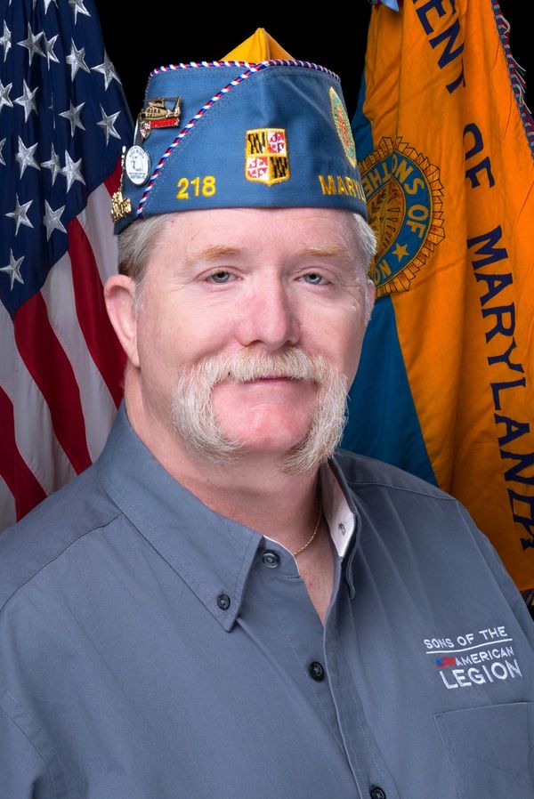 Veteran in Sons of the American Legion uniform with Maryland flags behind.