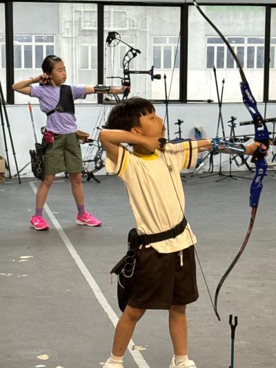 兩名種籽射箭的兒童班學員在練習反曲弓和複合弓