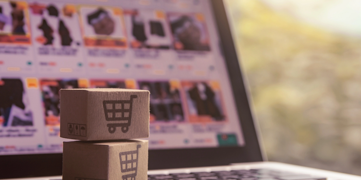 Miniature shopping boxes on a laptop keyboard symbolizing online shopping.