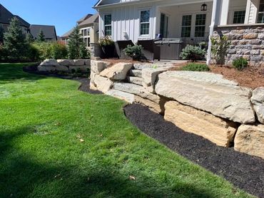 back patio with natural stone steps, hot tub, and entertaining space